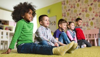 Five smiling children sitting on floor in Pre-K 