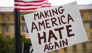 A 'Making America hate again' poster in the brown font on a white background and the American flag b...