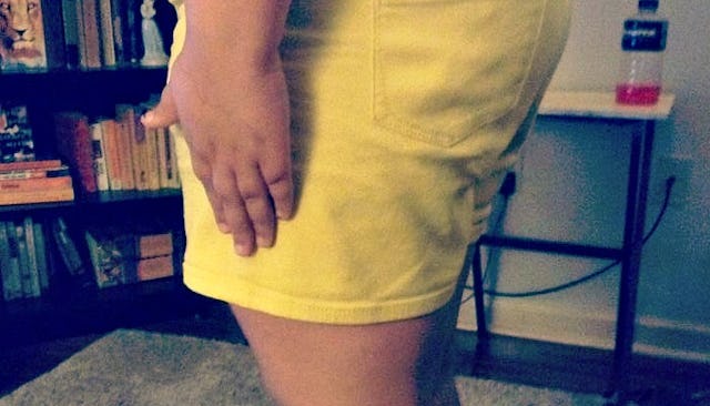 A girl standing in a yellow skirt, trying to fit in with the necessary dress code 