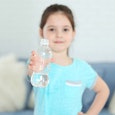 Girl holding a bottle of water, getting ready to flip it 