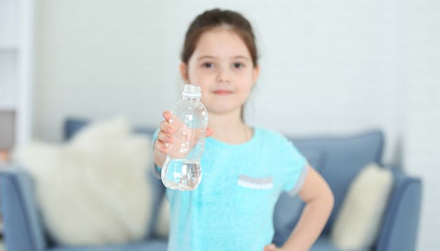 Girl holding a bottle of water, getting ready to flip it