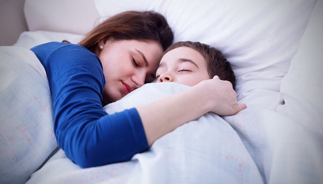 Мать с сыном спят в кровати