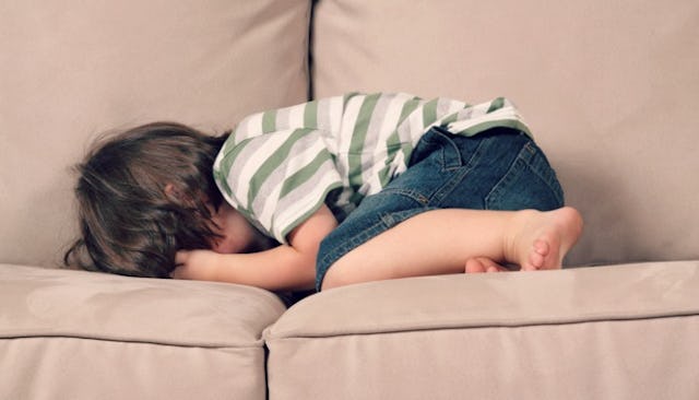 Child laying on the couch feeling bad and crying