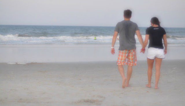 A couple walking on the beach holding hands