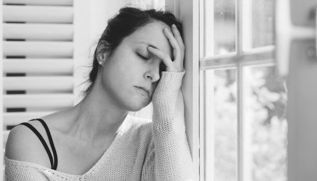 A woman desperately holding her head, believing she is not good enough