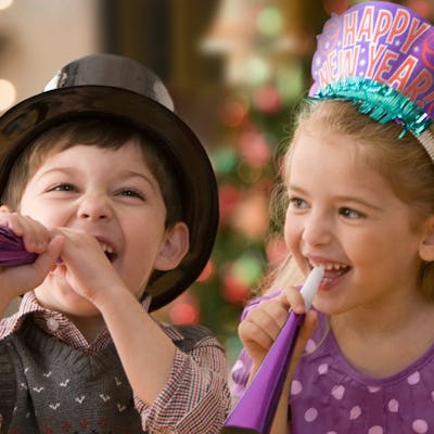 A small boy and girl celebrating New Year's Eve at home