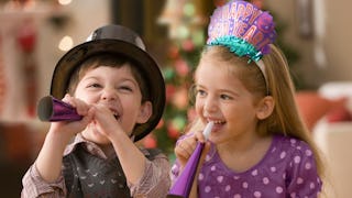 A small boy and girl celebrating New Year’s Eve at home