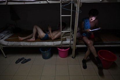 This photo taken on September 14, 2016 shows workers relaxing in their dormitory room after a shift ...