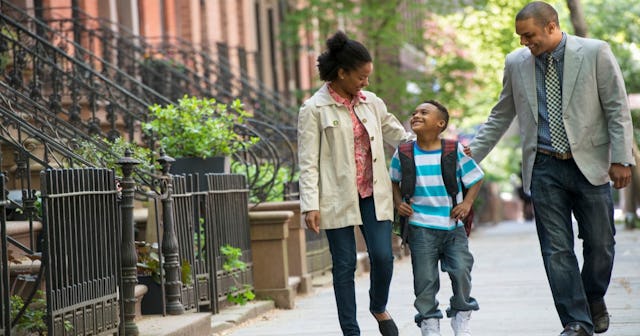 Ex-lovers co-parenting and walking down the street with their kid