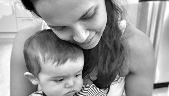 A mom struggling with postpartum health anxiety hugging her baby