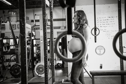 Photograph from a maternity shoot of a fit mom standing in the gym