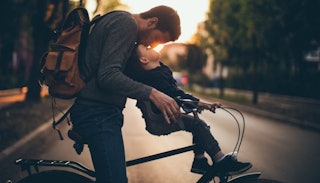 Dad kissing his son on the bicycle