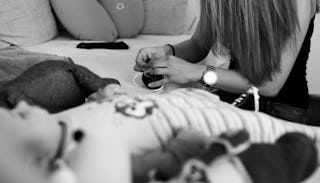 A foster mother holding a small shoes and a toddler on a couch in black and white