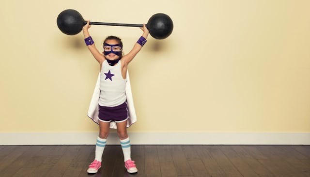 A girl wearing pink sandals, blue and white wrestler outfit with a blue star on the shirt while hold...