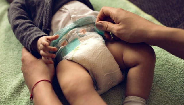 A mother changing her baby's diaper
