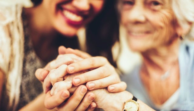 The daughter happily holding hands with her mother, who is navigating life with Alzheimer's.