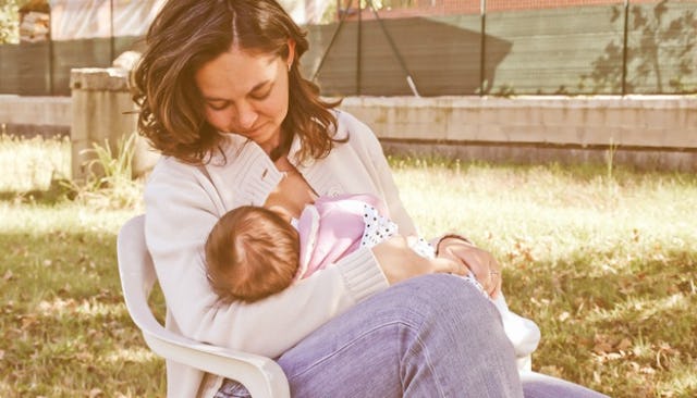 A young mother holding and breastfeeding her baby