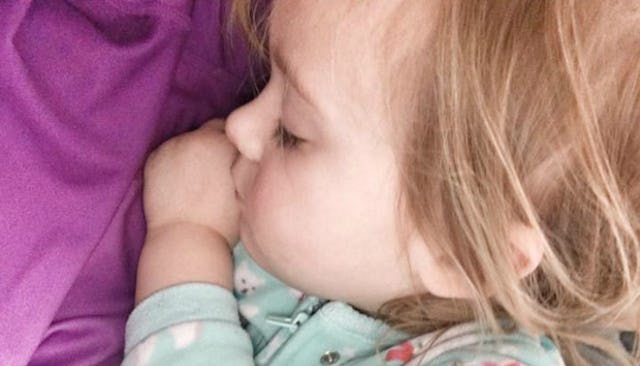 A sleeping toddler in a blue sweater