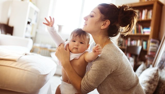 A mom getting her toddler dressed as she gets ready to go back to work