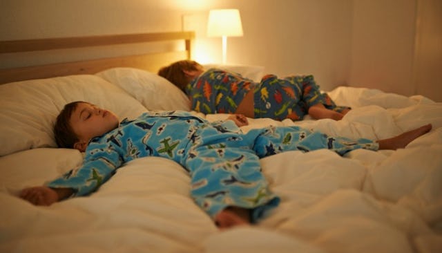Two toddler boys who fell asleep in a large bed without sleep-training