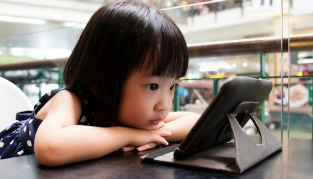 Little girl watching YouTube on her tablet