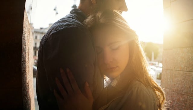 A daughter leaning against her parent with high functioning anxiety and hugging while the sun is set...