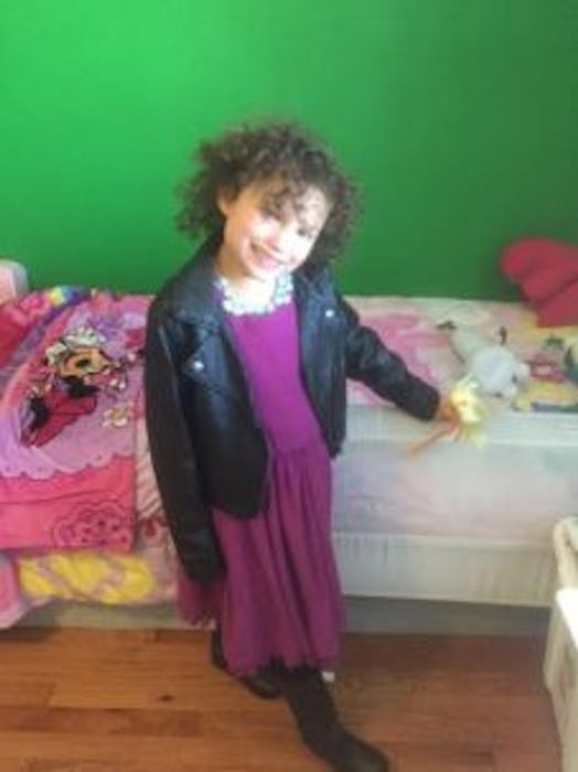 Leah Moore's daughter as a toddler in a purple dress and black jacket 