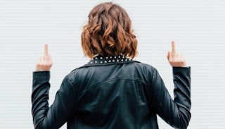 Woman with her back turned, in a leather jacket, showing two middle fingers