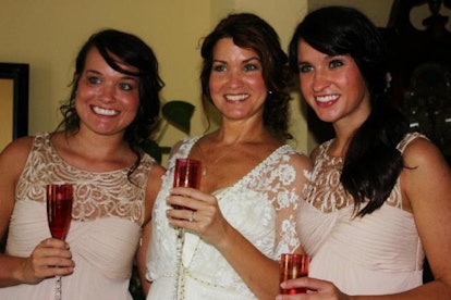 Three women smiling and holding glasses with champagne. 