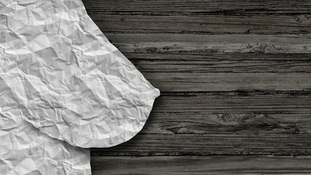 A mockup of a woman's breast represented in the form of crumbled-up paper, symbolizing mammograms