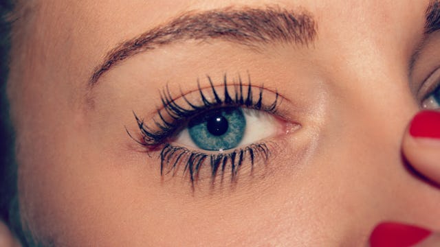 A close-up of a blue-eyed girl's eye, who's wearing mascara on her upper and lower lashes