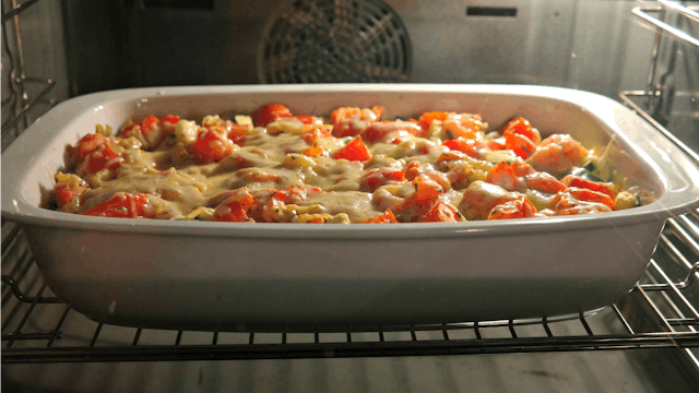Casserole in a white container being baked in an oven