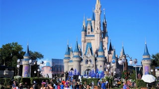 The outside of a Disneyland resort with a large crowd in front of it