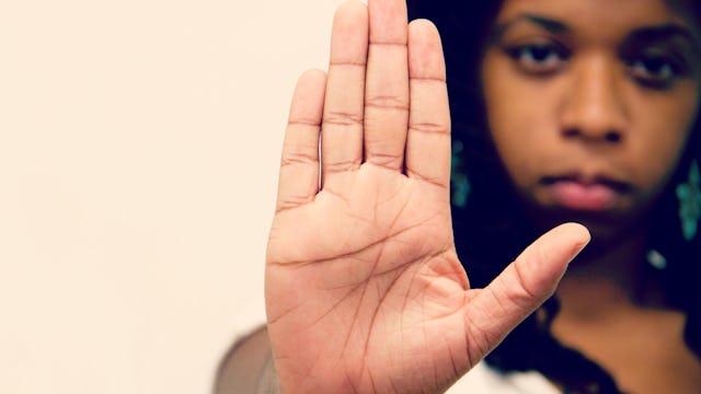 A black woman raising her hand, showing her anger 