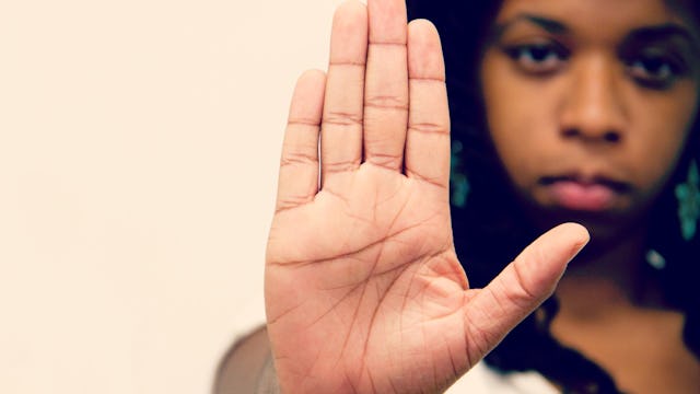A black woman raising her hand, showing her anger