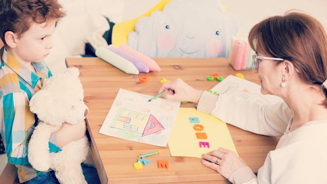 A mother showing a drawing on a table to her son who has apraxia