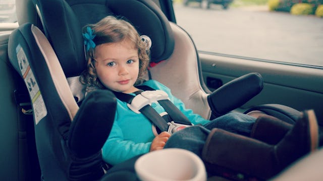 A blue-eyed girl sitting in a car seat