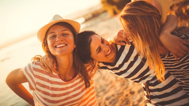 Three moms in striped shirts at the beach on a girls' trip