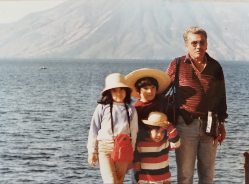 Kids with their dad standing on a shore with a mountain in the back in Guatemala.