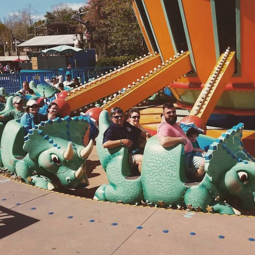 Three adults and a kid on a ride in Disneyland.