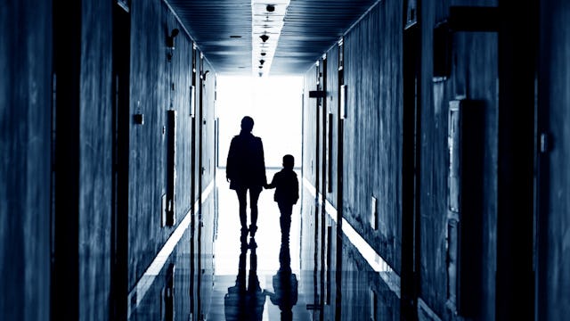 A mother clasping her daughter's hand as they stride toward the radiant glow.