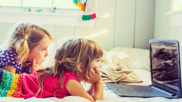 Two girls in their bedroom looking at videos on the laptop because they don't have a screen time lim...