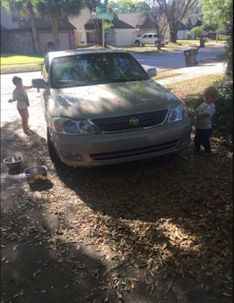 Two little boys washing a car 