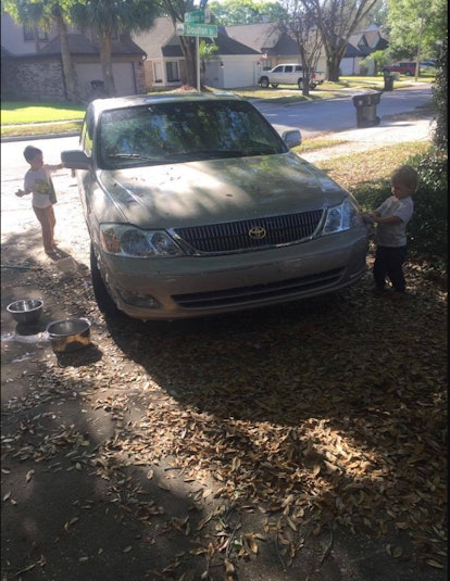 Two little boys washing a car 