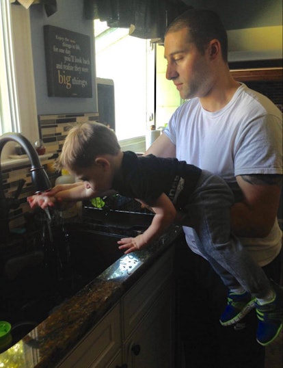 A dad helping his son wash hands 