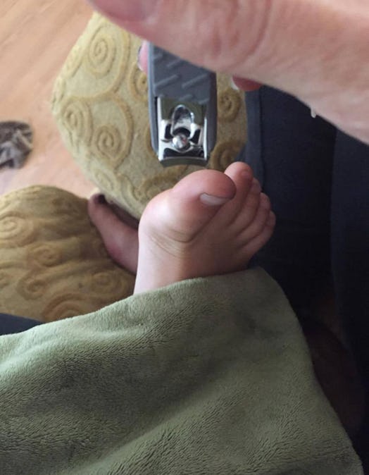 A dad clipping kid's toenails