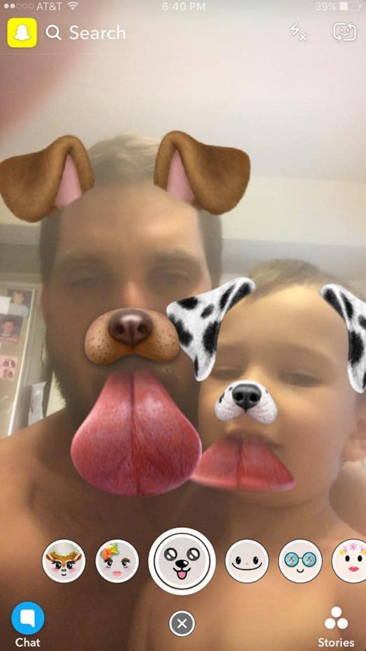 A dad and a son taking a selfie with a Snapchat filter