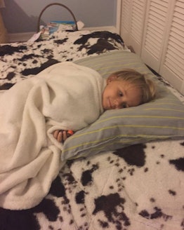 A child sleeping on a mattress on the floor 