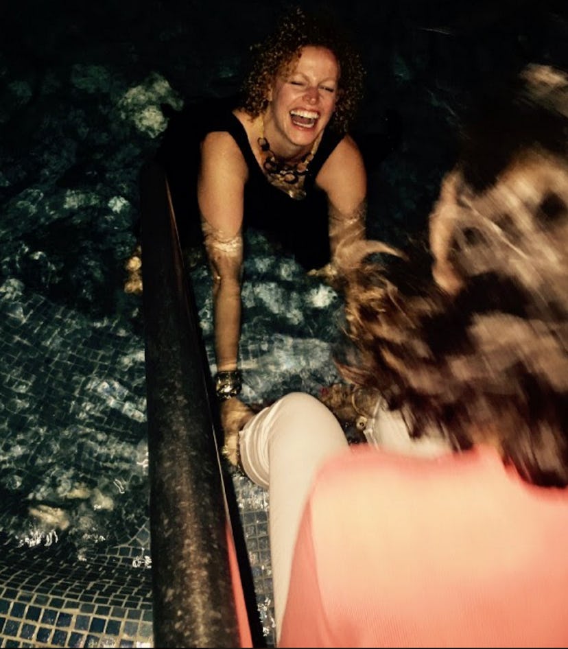 Two moms on a girls' trip going into the hot tub fully clothed