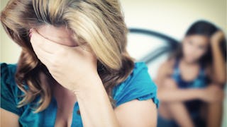 Angry mom desperately covering her face with hands in anxiety